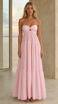 Front view of a pink strapless twist-front tiered maxi dress