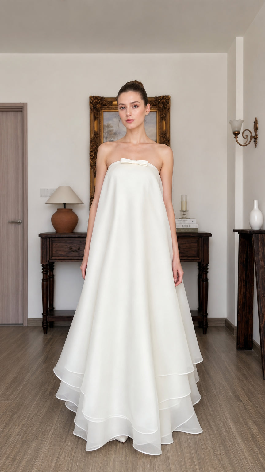 Front view of woman wearing white strapless tiered long dress