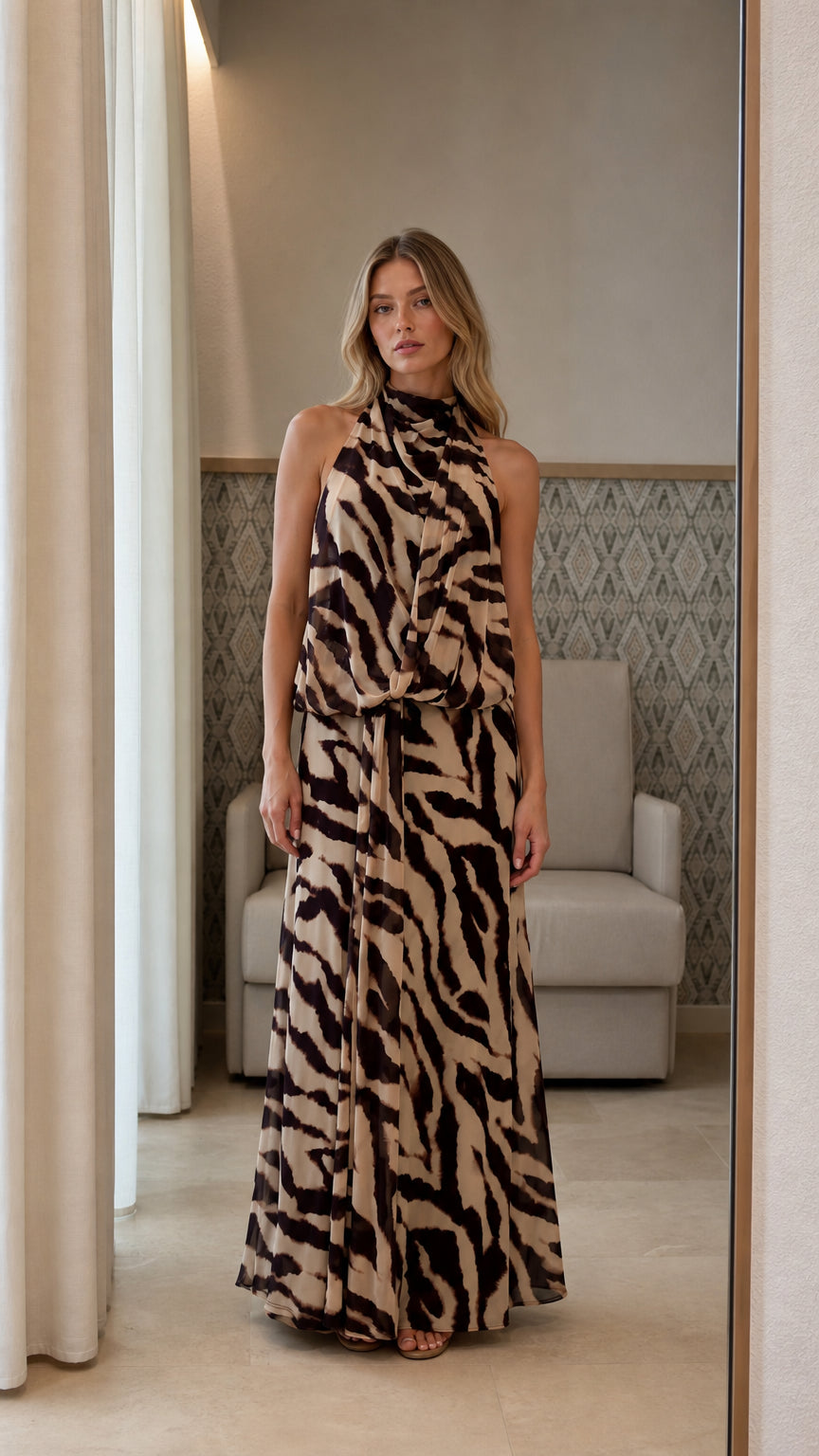Front view of model wearing beige animal print halter neck maxi dress