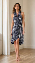Front view of woman wearing navy blue gingham halter ruffle midi dress