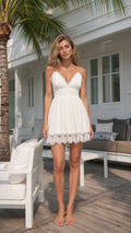 Front view of woman wearing white lace trim mini dress