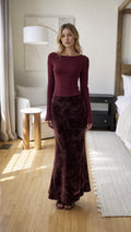 Front view of burgundy long sleeve top and velvet floral maxi skirt set