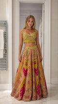 Front view of woman wearing yellow embroidered crop top and lehenga set