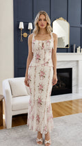 Front view of woman wearing ivory floral midi dress with tie straps