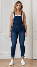 Front view of woman wearing blue denim overalls and white sneakers