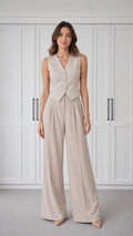 Front view of woman wearing beige tailored vest and wide-leg pants set