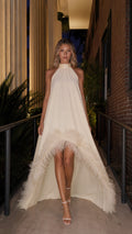 Front view of ivory high-low feather trim halter maxi dress