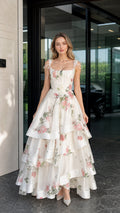 Front view of woman wearing white floral tiered maxi dress