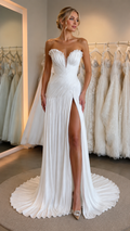 Front view of white strapless pleated sweetheart gown with high slit and sweep train