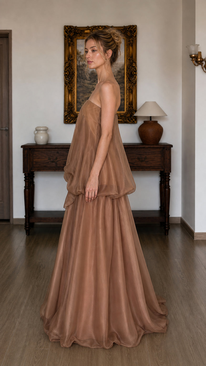 Side profile of model in brown strapless maxi dress