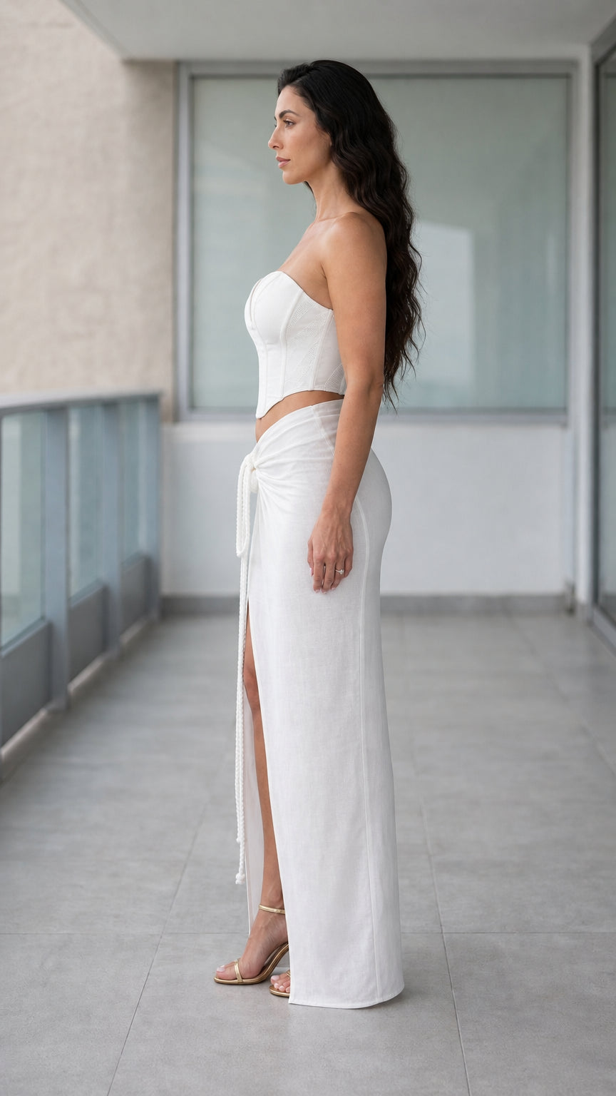 Side profile view of woman wearing white two-piece corset and skirt set