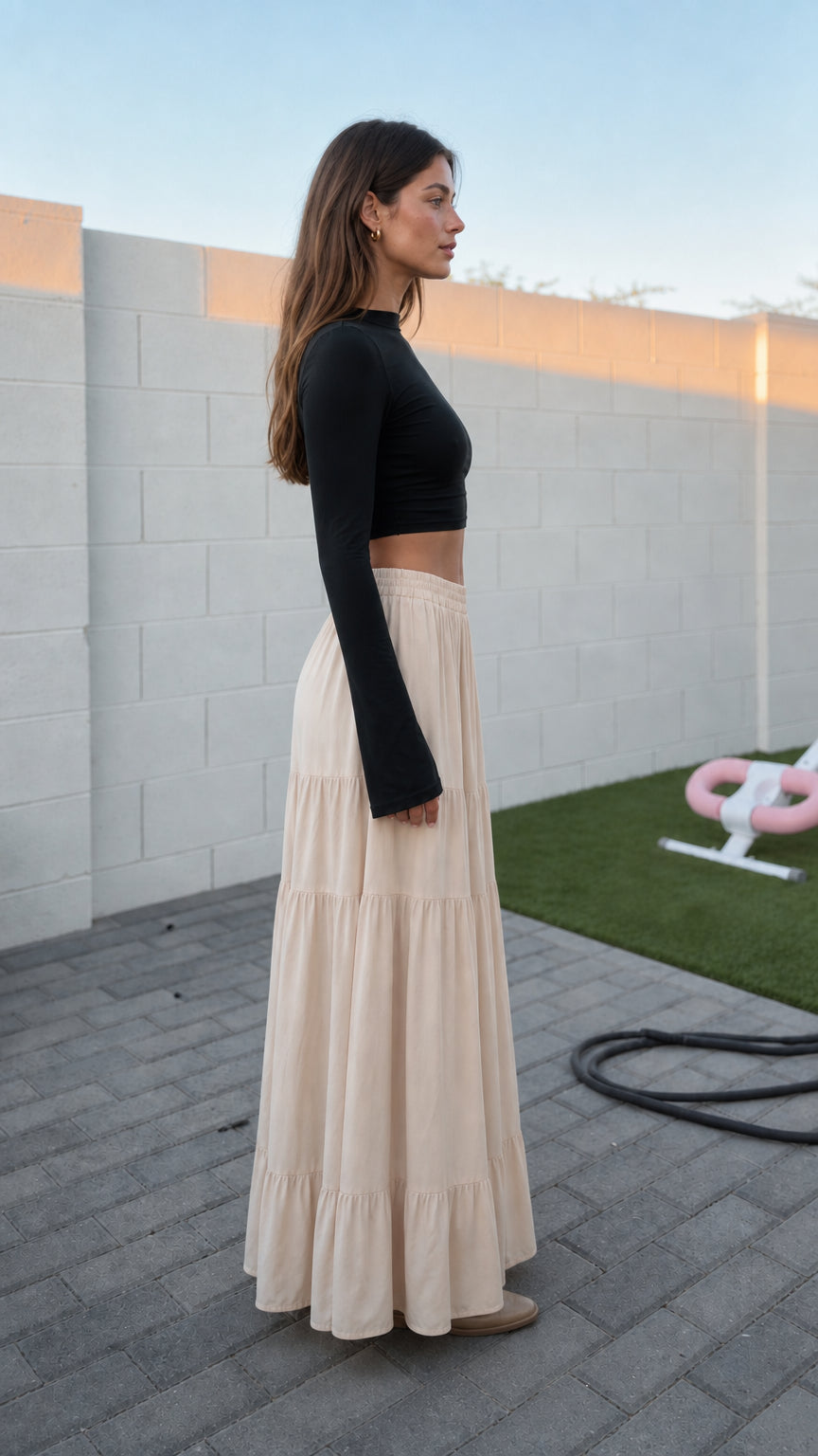 Side profile of model in beige tiered maxi skirt