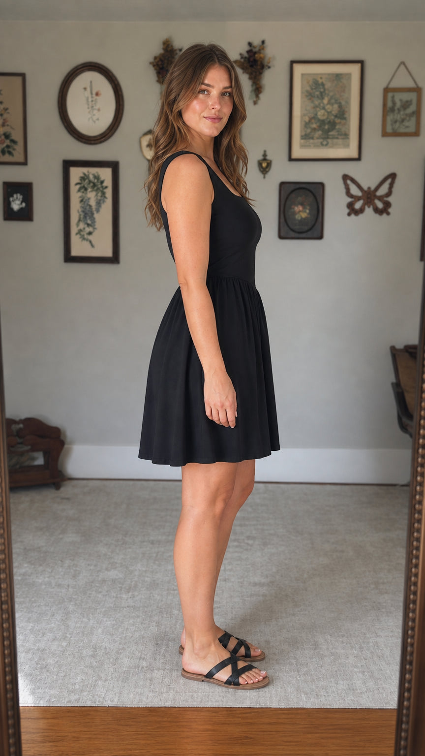 Side profile view of woman in black drop-waist mini dress