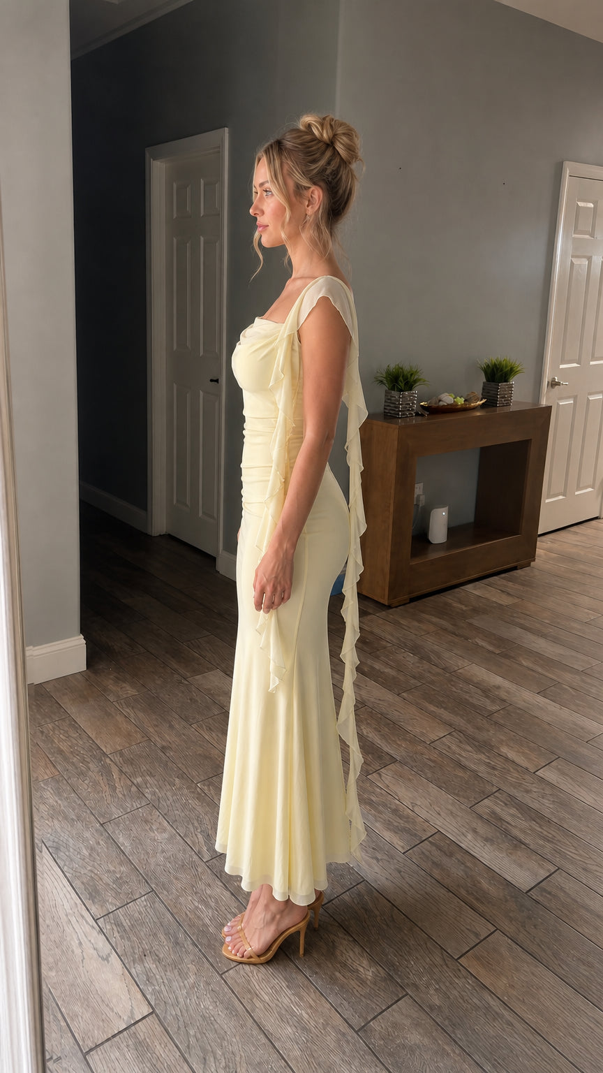 Side profile view of model wearing the yellow maxi dress with cascading ruffles
