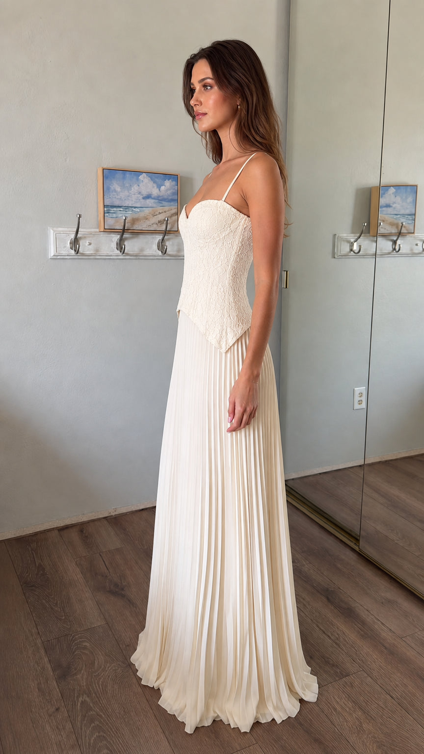 Side profile of woman wearing white lace corset bodice pleated maxi dress