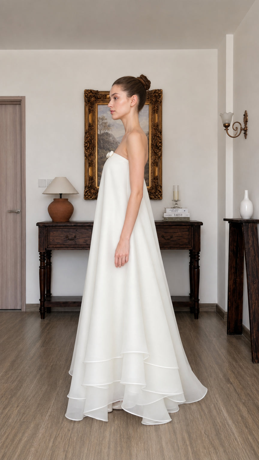 Side profile view of white tiered long dress