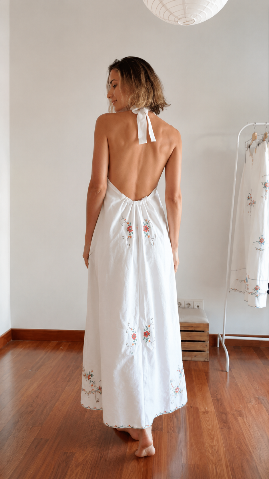 Back view of white halter maxi dress showing open back and tie neck