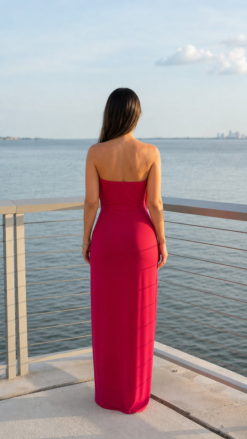 Back view of woman wearing fuchsia strapless cowl neck maxi dress