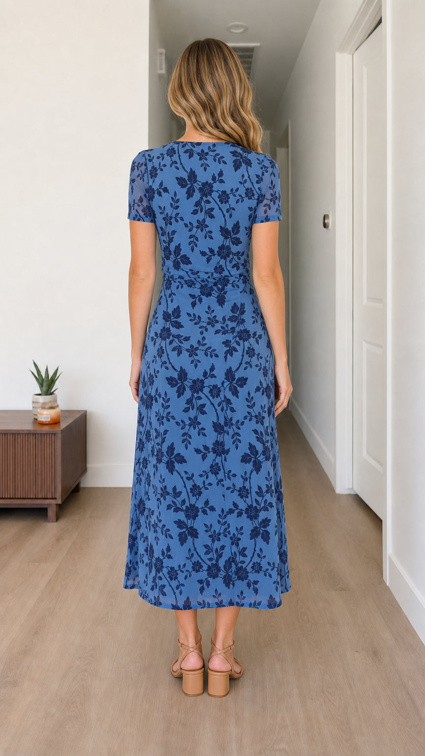 Back view of woman wearing blue floral midi dress