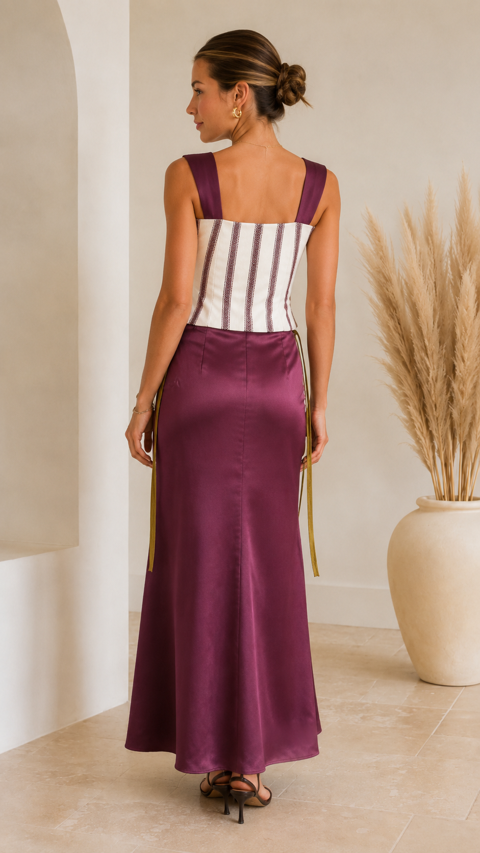 Back view of plum striped corset maxi dress with wide straps