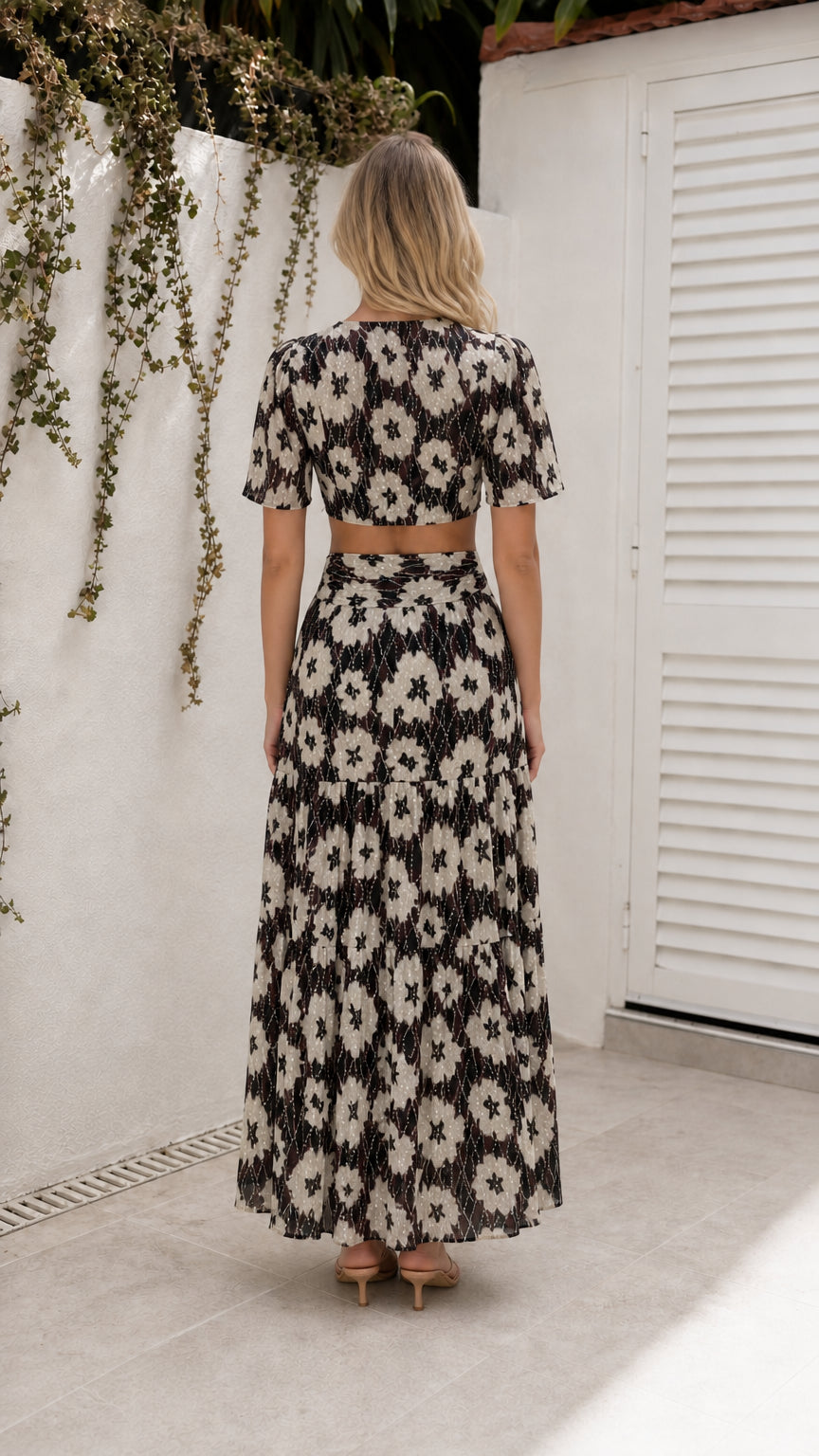 Back view of model wearing black floral cutout maxi dress