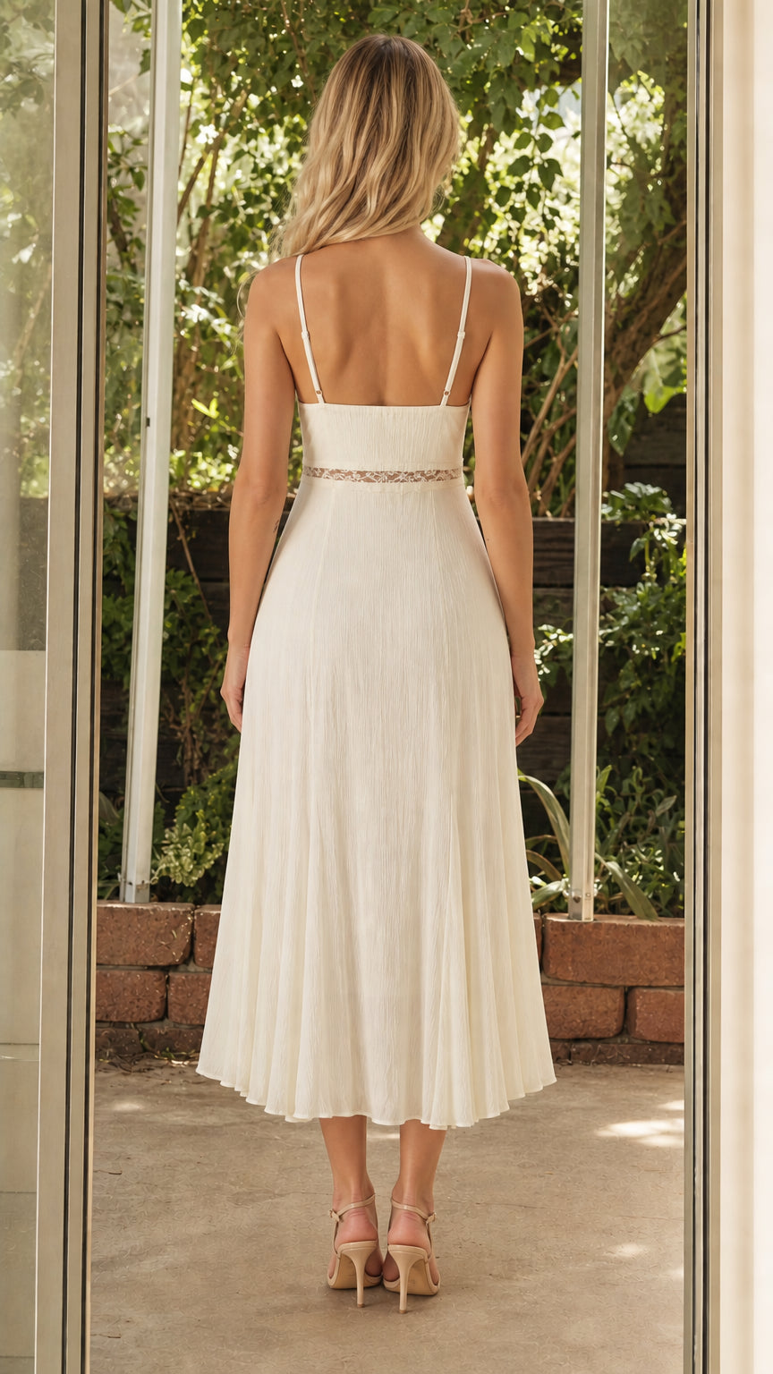 Back view of model in white pleated midi dress