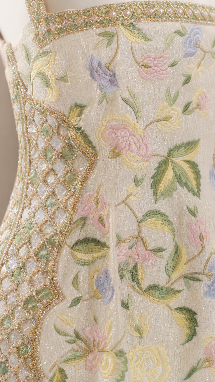 Close-up detail of multi-color floral embroidery and metallic lattice trim