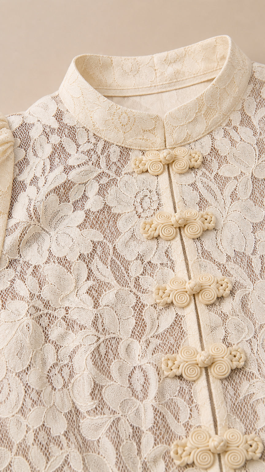 Close-up of cream lace top showing Mandarin collar and knot buttons