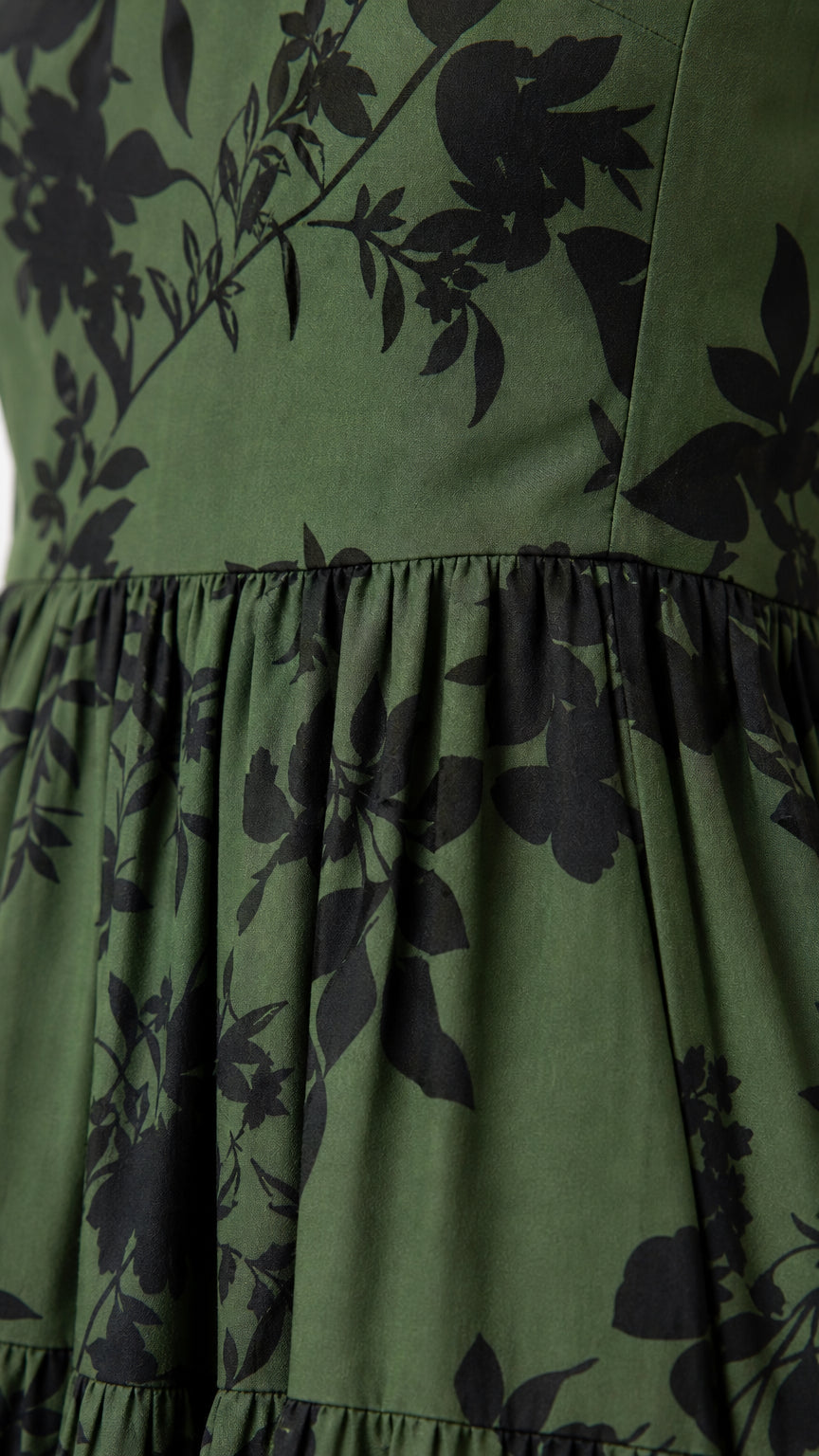 Close up of green floral fabric and tiered skirt detail