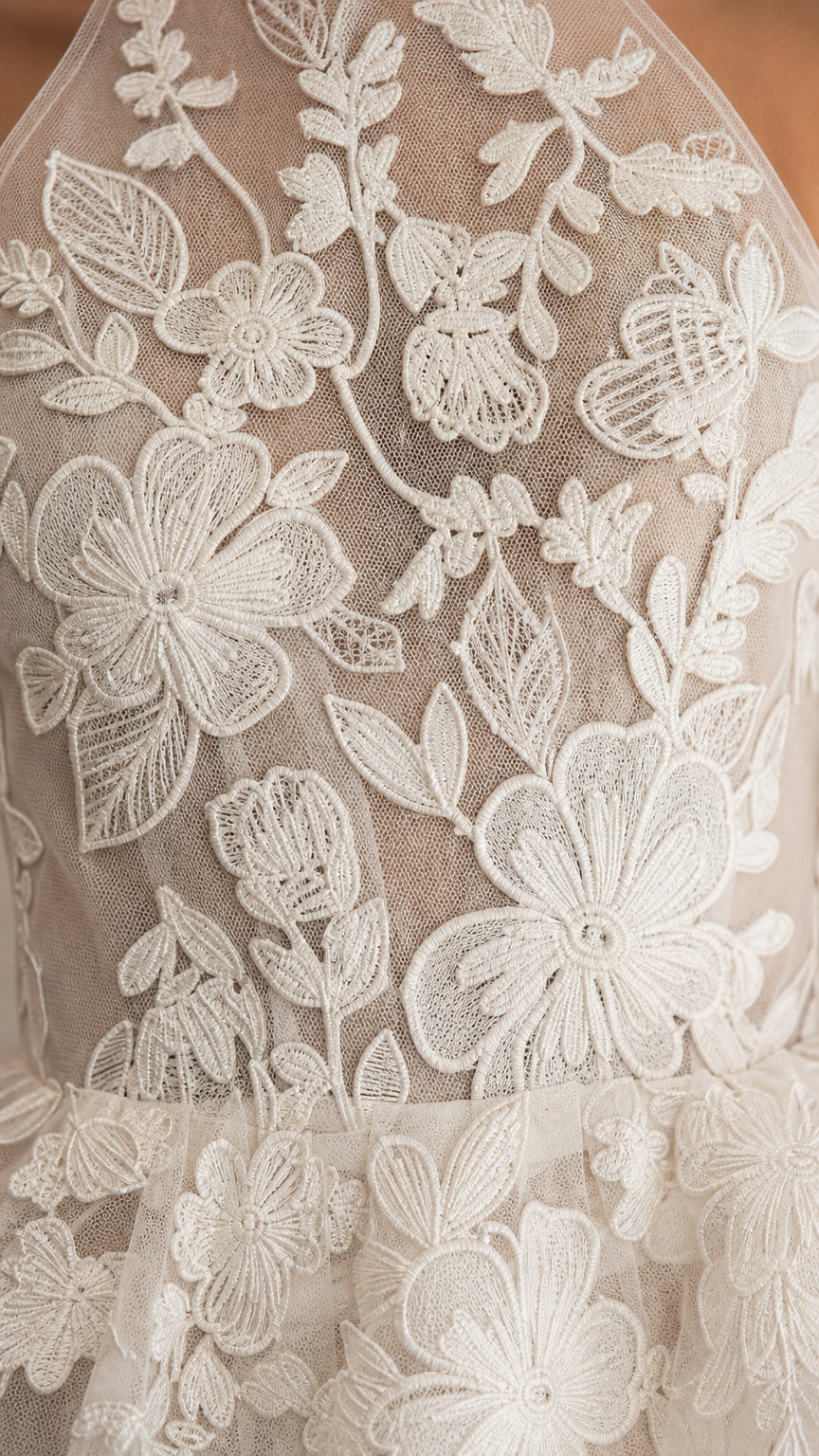 Close-up detail of white floral embroidery and mesh fabric