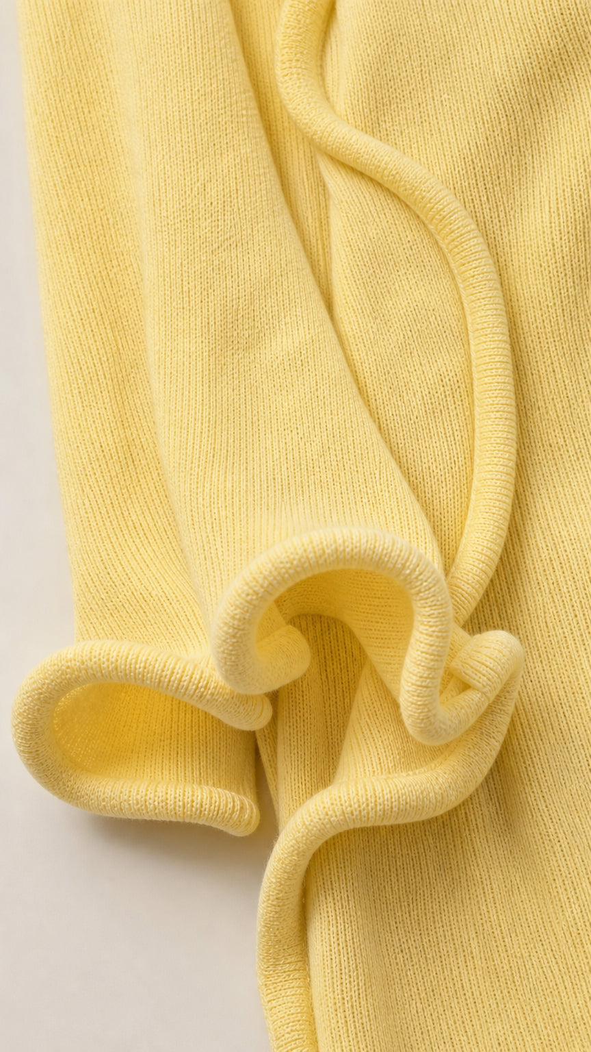 Close-up detail of yellow knit fabric and ruffle texture