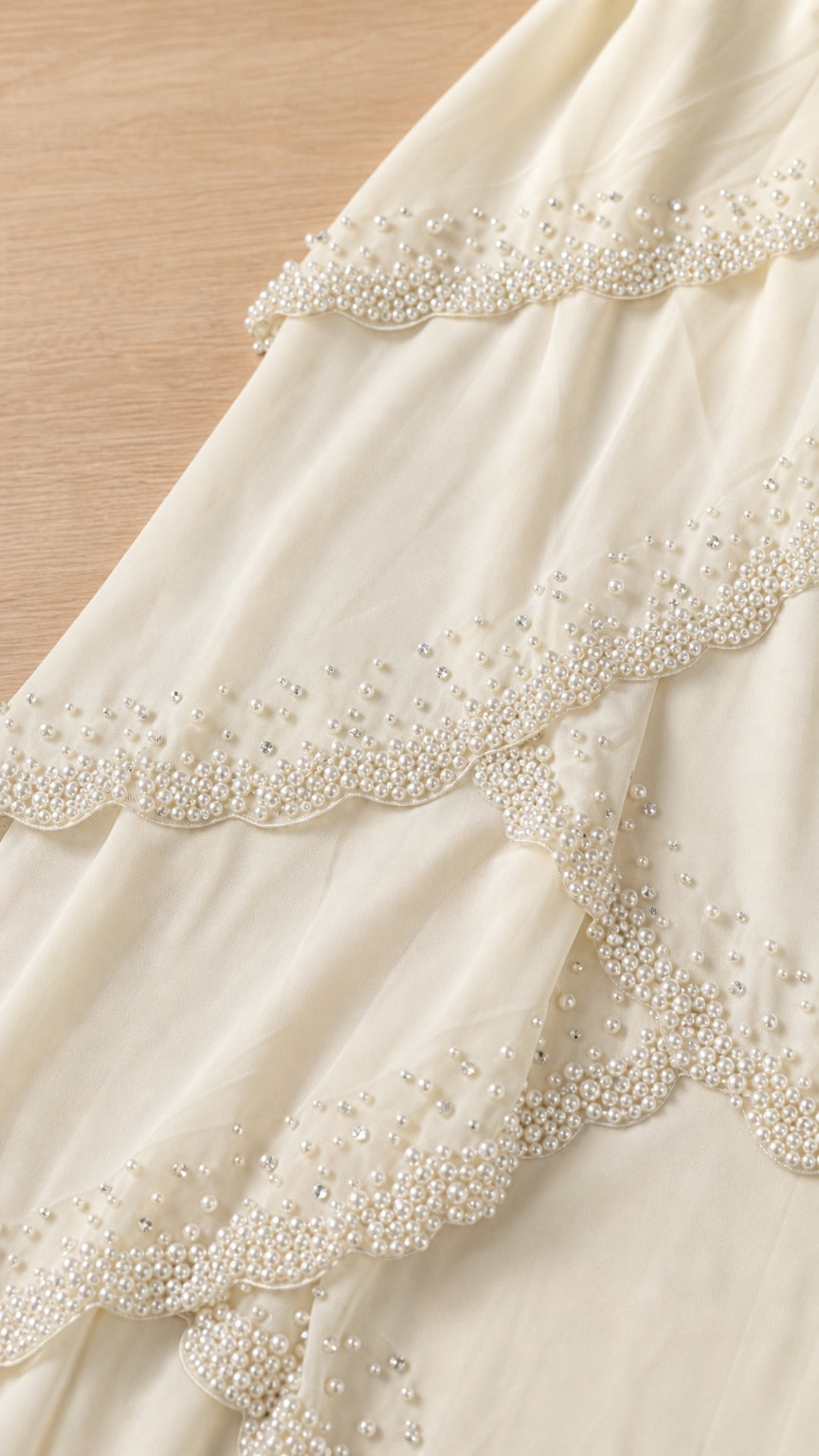 Close up of beaded trim on ivory tiered dress