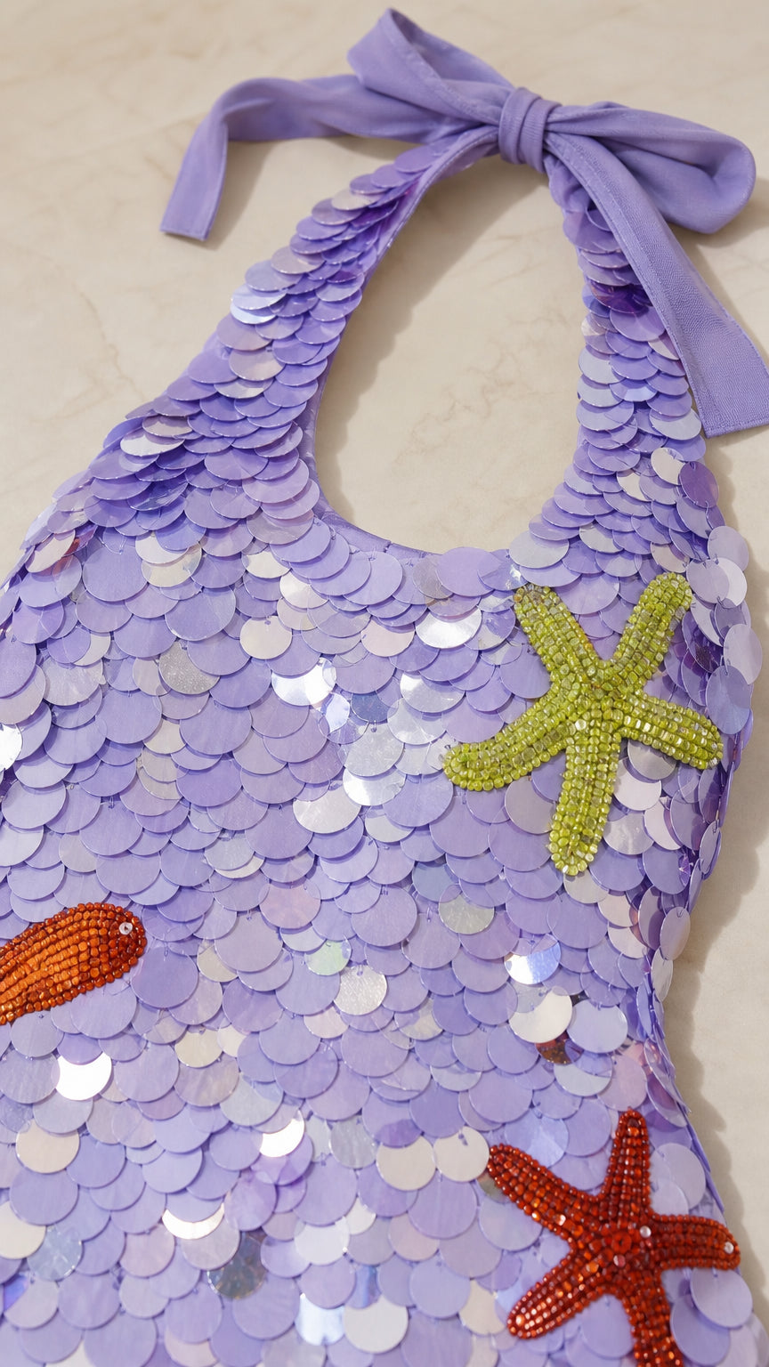 Close-up of halter tie and sequin texture on lilac romper