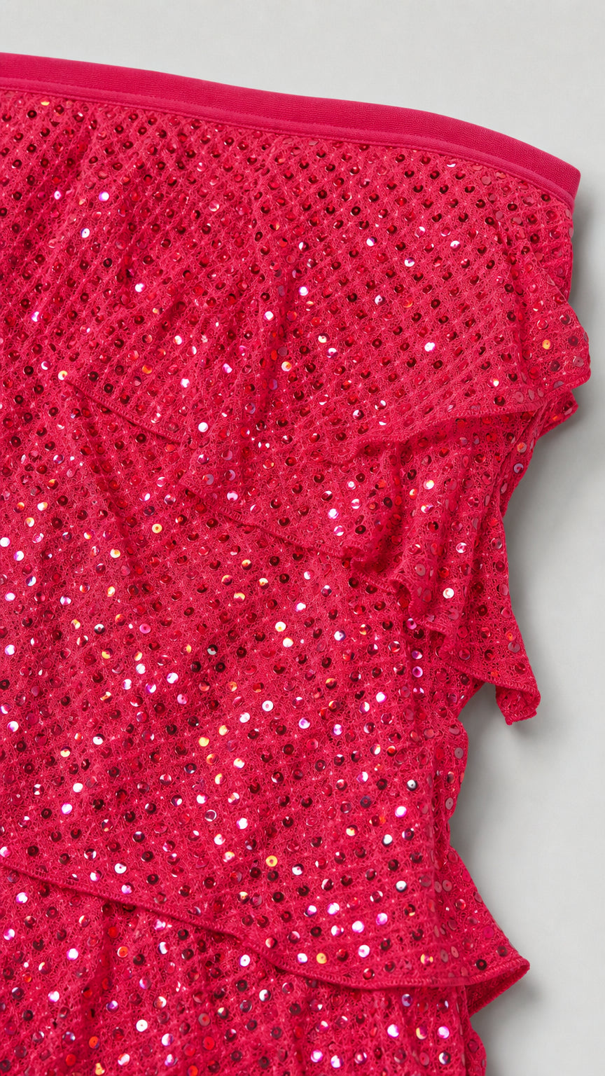 Close-up detail of hot pink sequined fabric and ruffle trim