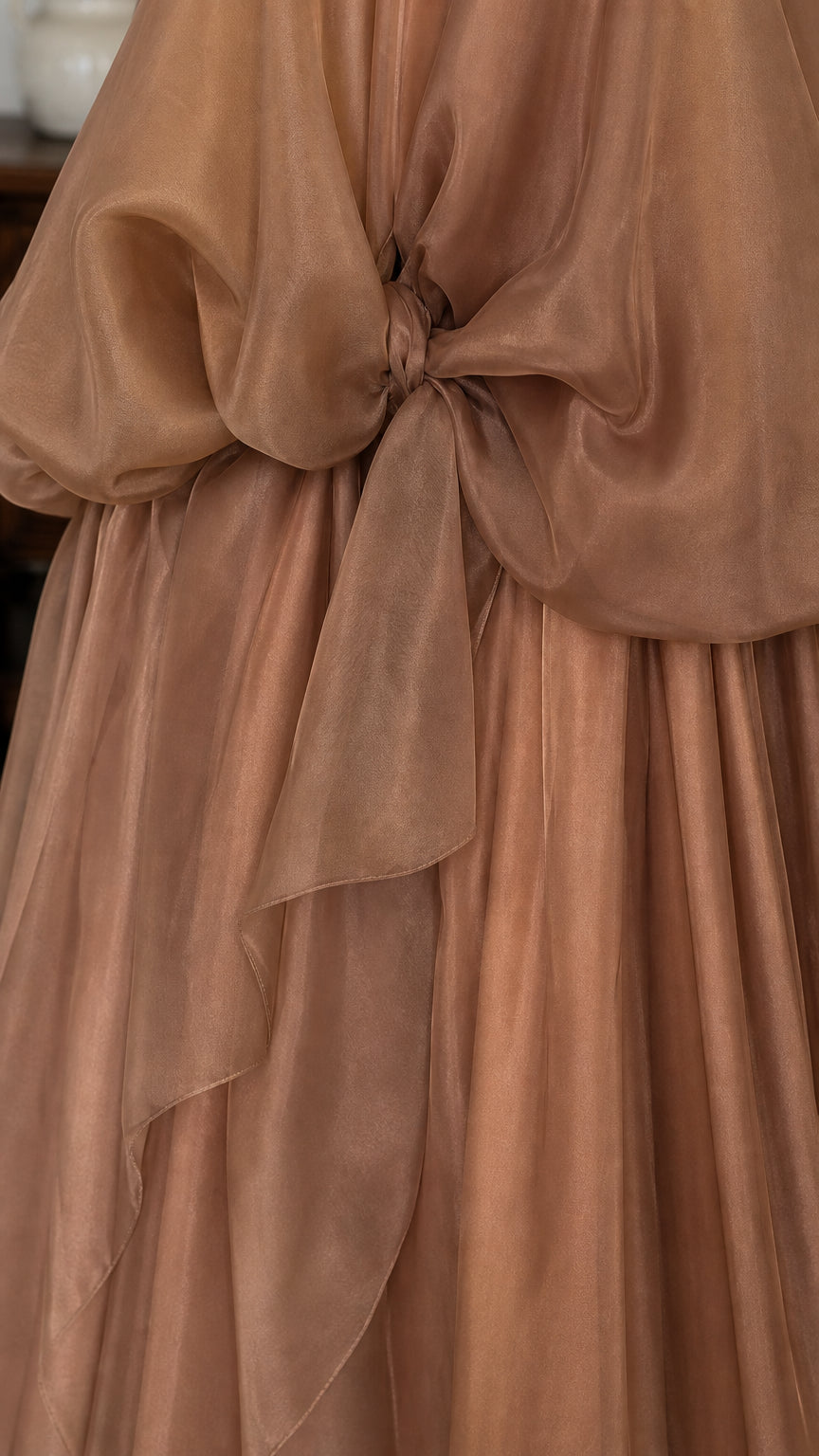 Close-up detail of front tie and fabric texture on brown dress