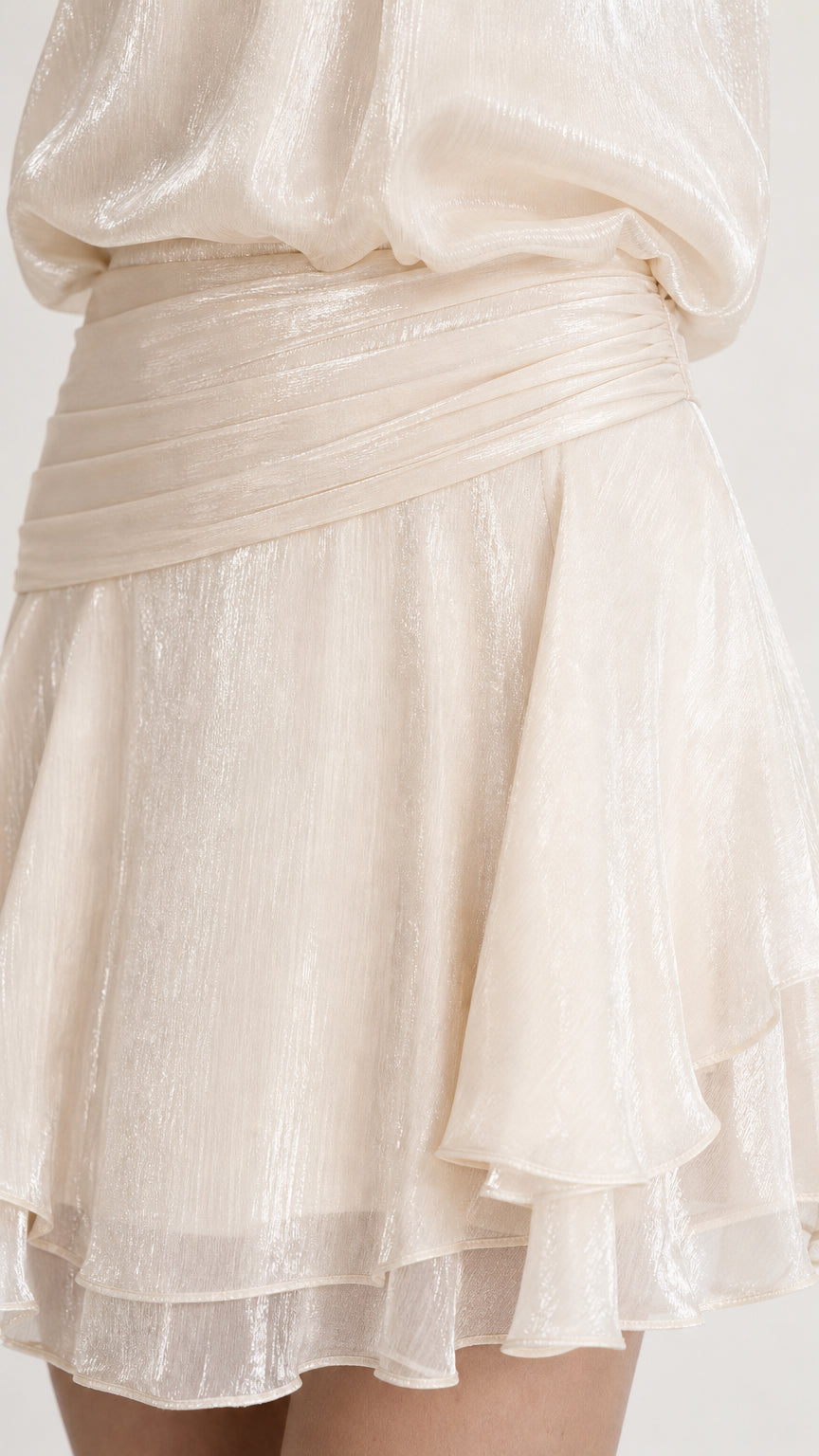Close-up detail of draped waistband and ruffled hem