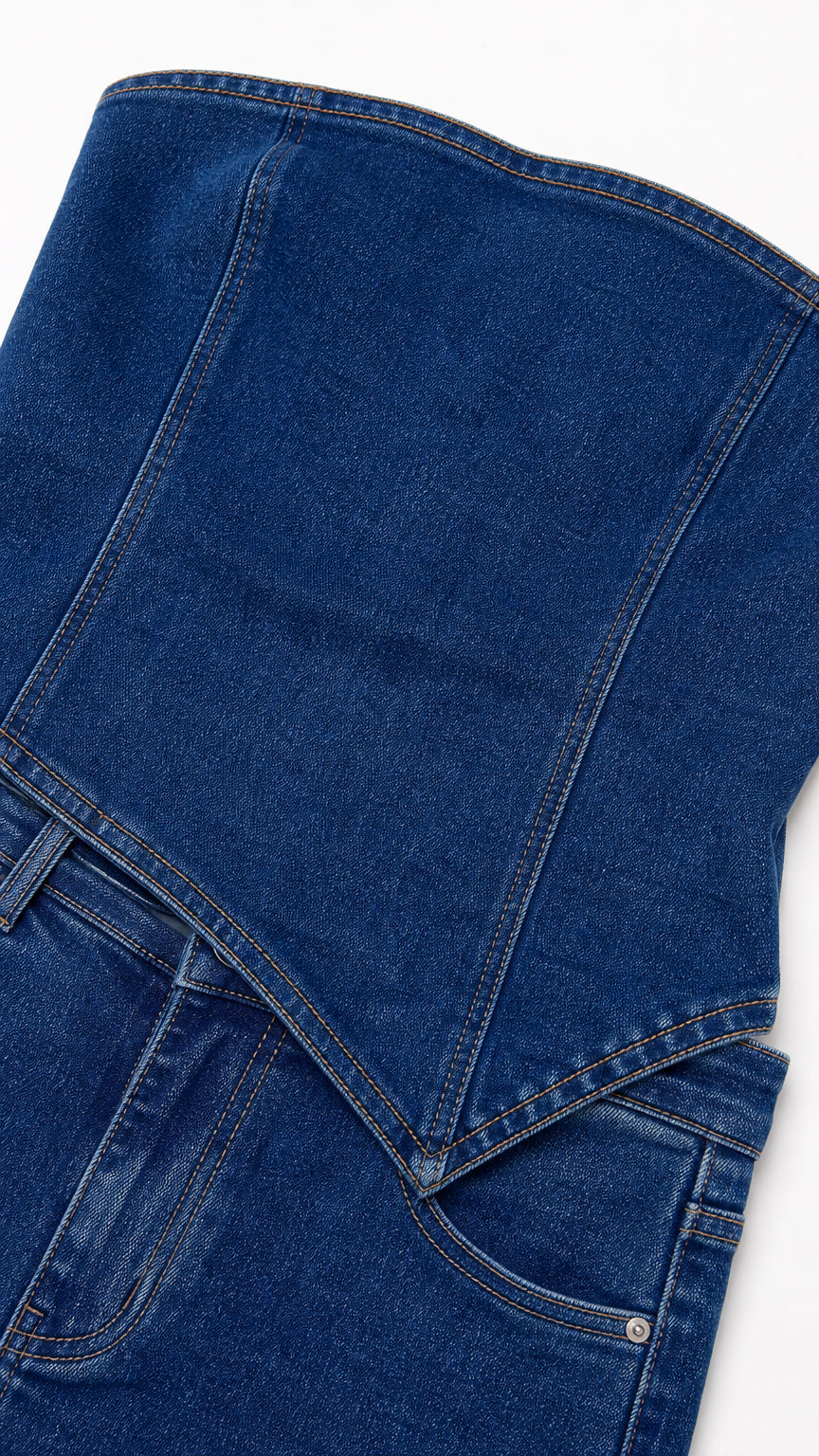 Closeup detail of blue denim fabric and asymmetric waist stitching