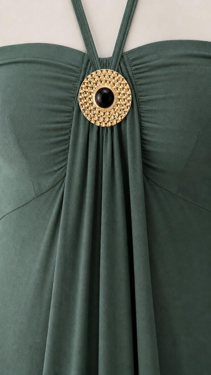 Close-up of metallic ring accent on green dress neckline