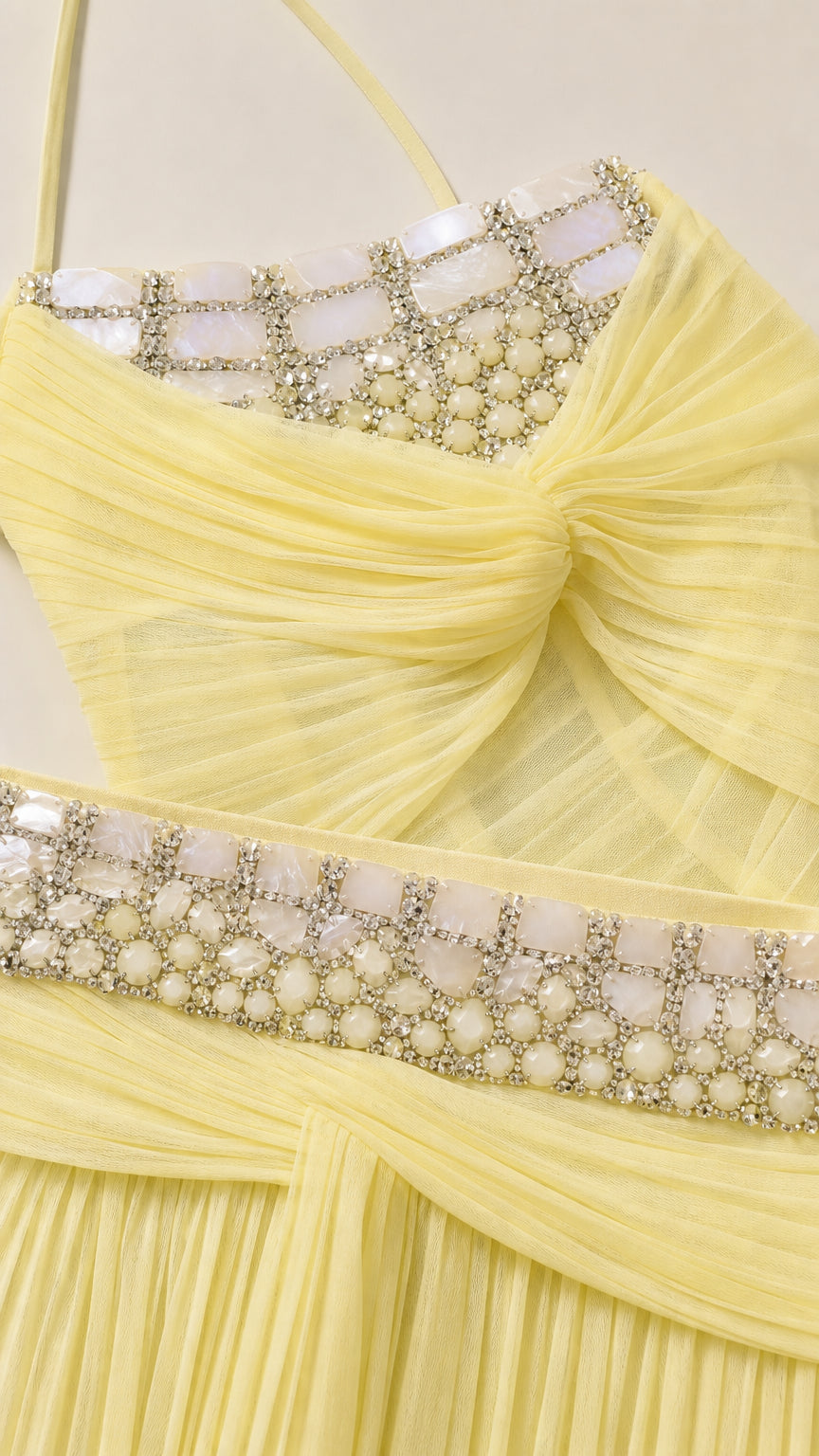 Close-up detail of rhinestone and pearl embellishments on the yellow corset and waistband