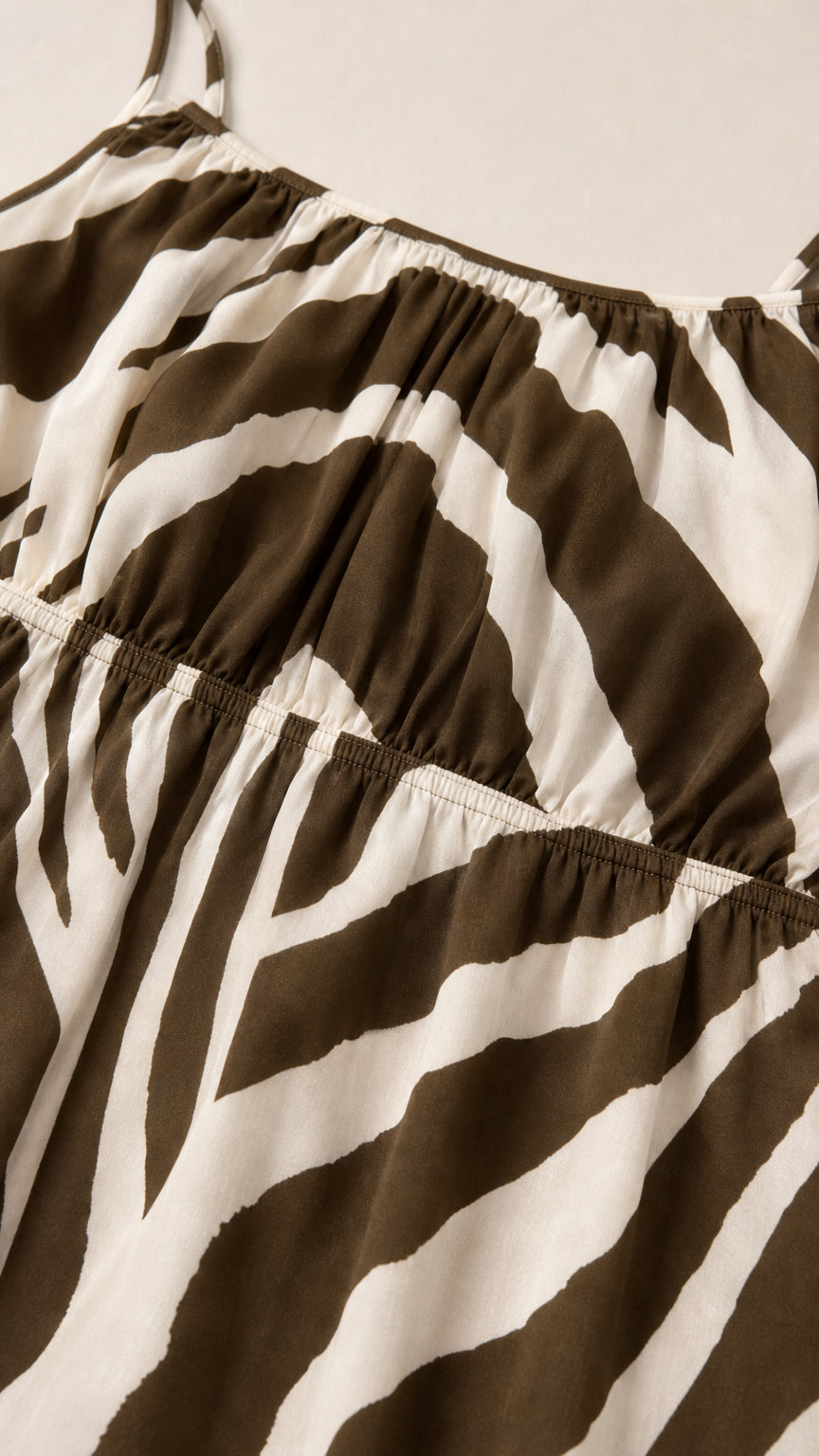 Close-up detail of smocked bodice on brown zebra print dress