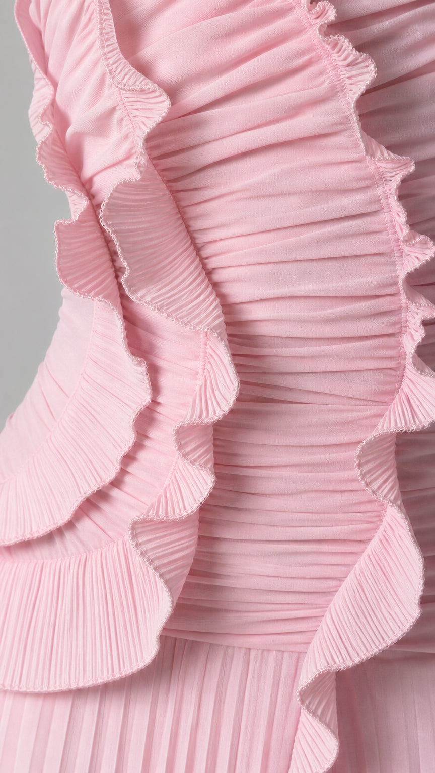 Close-up detail of accordion pleats and ruffle trim on pink dress