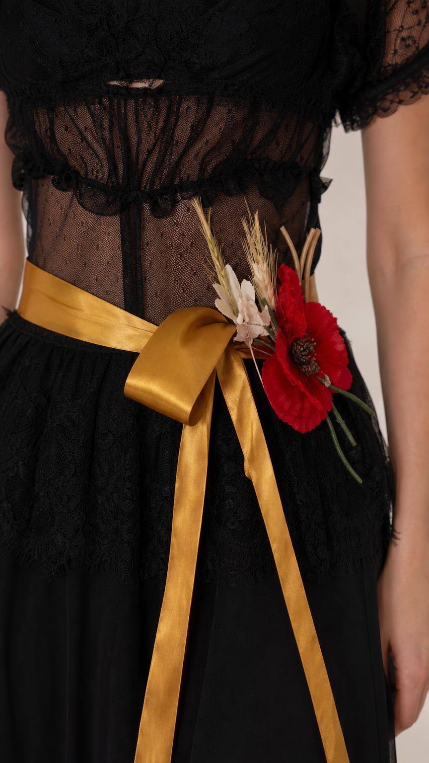 Close-up detail of bodice, lace, and gold floral sash