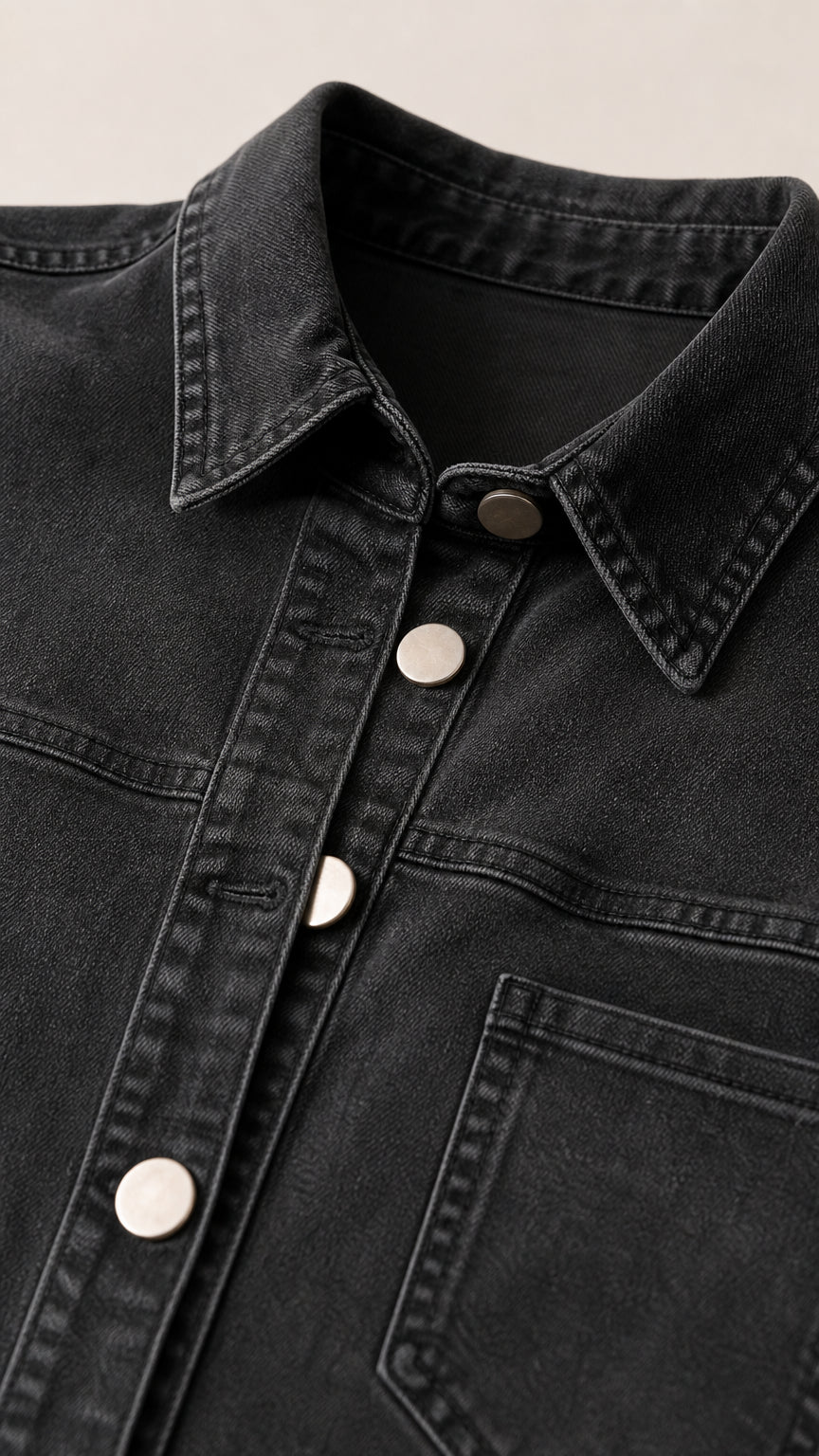 Close-up detail of collar and buttons on black denim dress