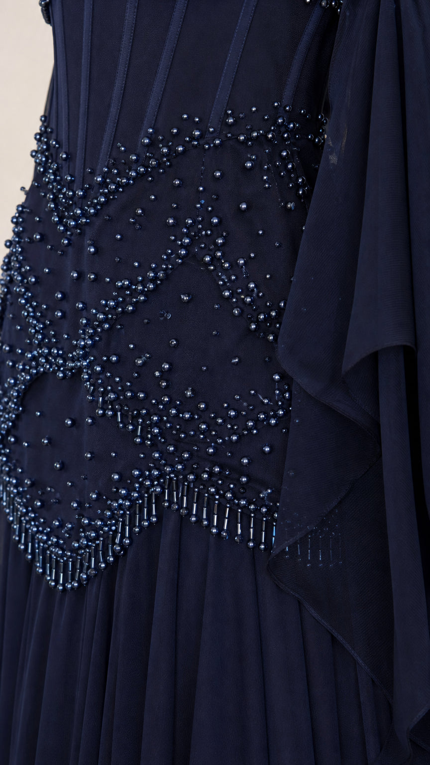 Close-up of intricate beadwork on the bodice of the navy evening gown