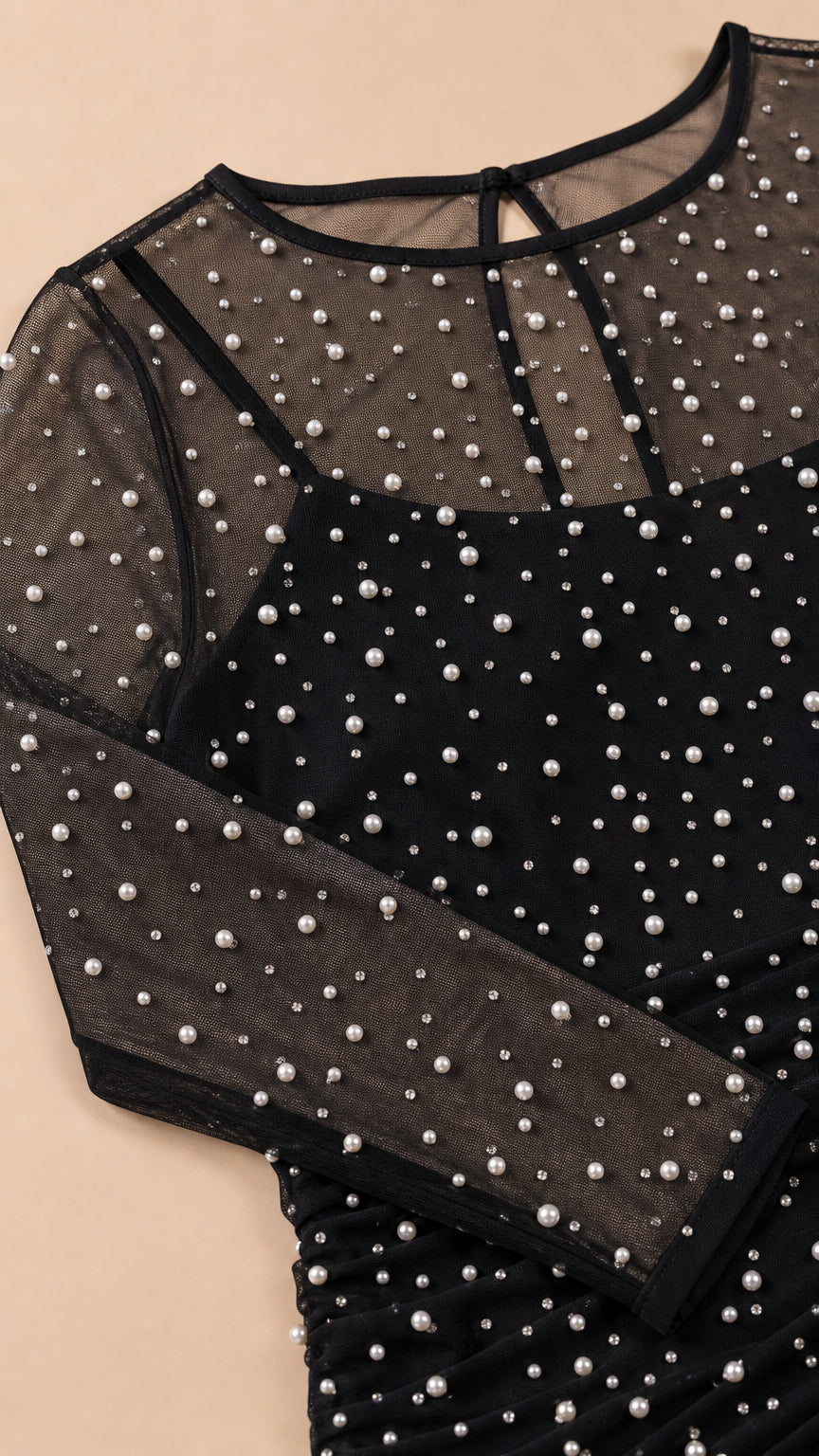 Close-up detail of sheer mesh and faux pearl neckline and sleeve