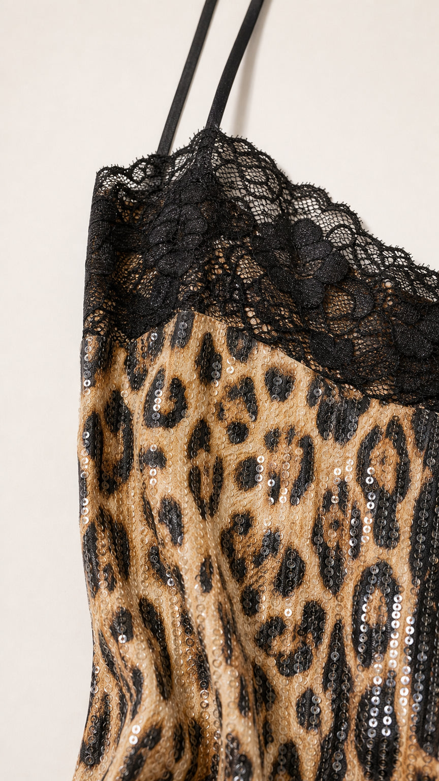 Close-up of black lace trim and sequin texture on leopard dress