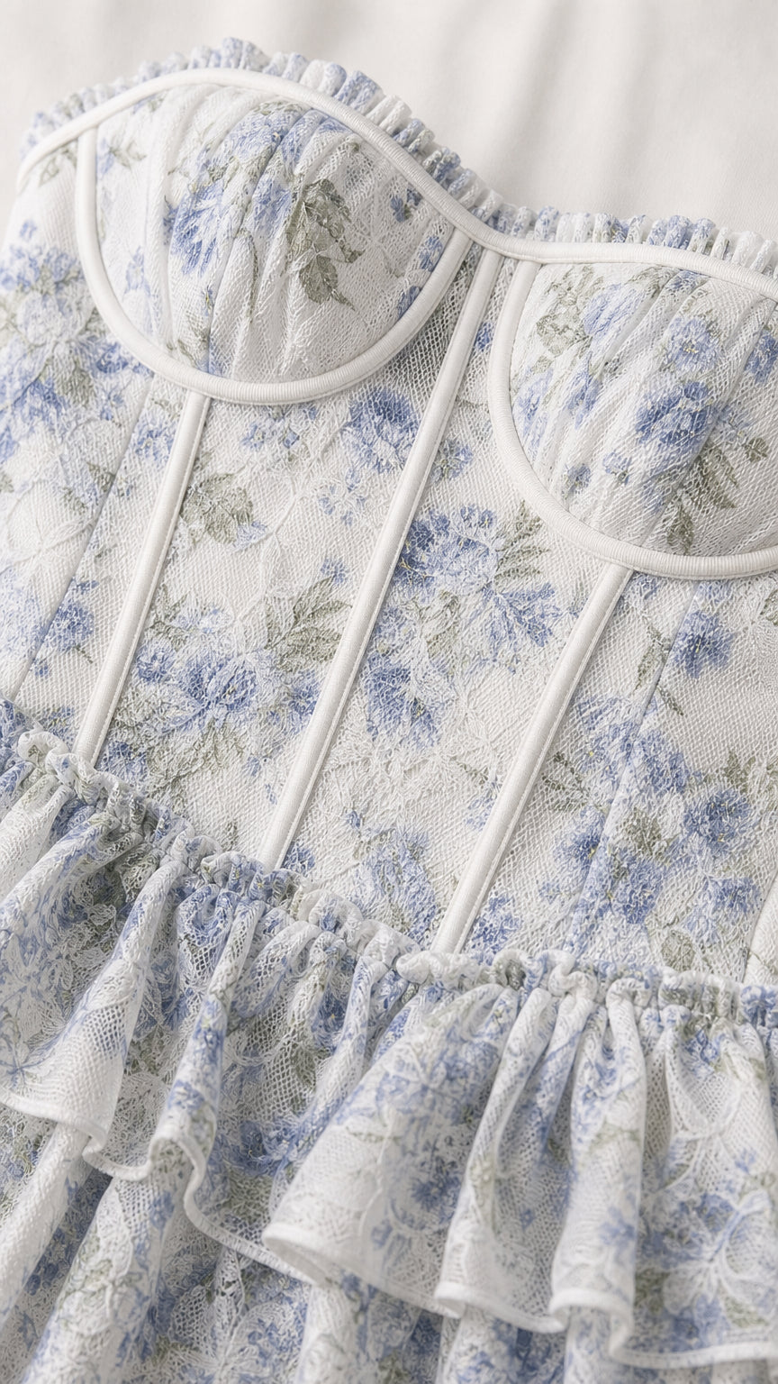 Close-up detail of white and blue floral bustier bodice with ruffles