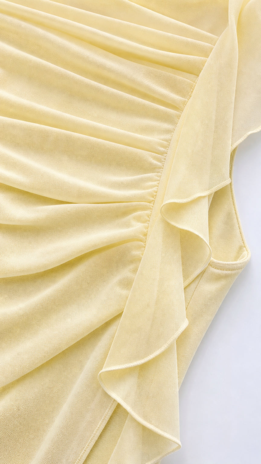 Close-up detail of yellow fabric texture and side ruffle construction