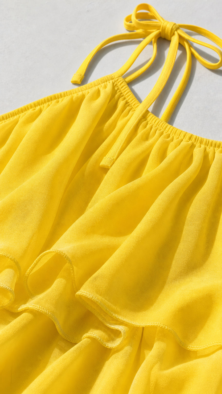 Close-up detail of pleated chiffon texture and self-tie straps in yellow