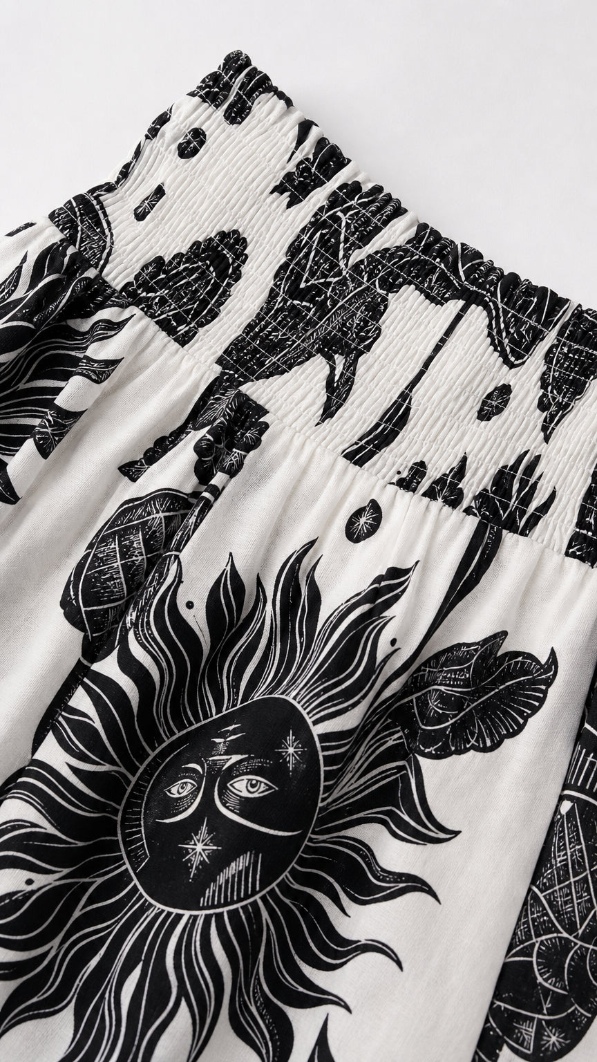 Close-up detail of smocked bodice and celestial sun print fabric